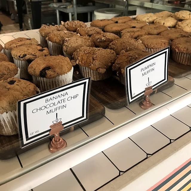 Banana chocolate chip and pumpkin muffins on wooden boards with their case cards